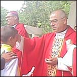 Mons. Grigore Duma, asociat la distribuirea acestui sacrament, n timp ce miruiete